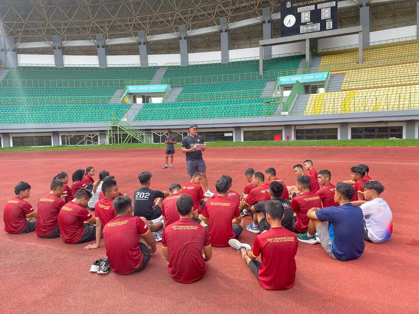 Pembina memberikan arahan kepada siswa Makala di stadion